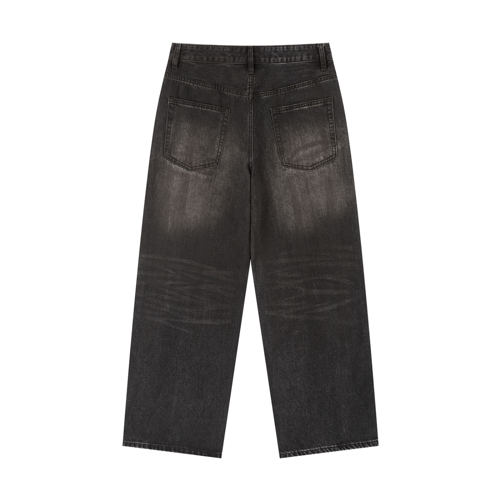 Back view of men's loose vintage wash heavyweight denim jeans in faded black with wide legs and rear patch pockets.